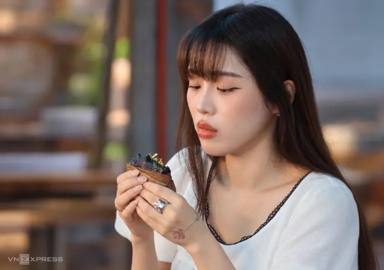 Ca sĩ Han Sara thưởng thức món bánh gai Tứ Trụ. Ảnh: Lê Hoàng